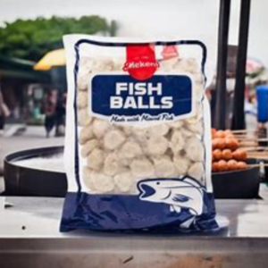 Package of fishballs labeled "Fish Balls made with Minced Fish" is placed on an outdoor food vendor's counter.